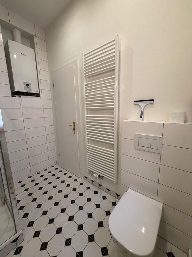 Koupelna s toaletou a sušákem na ručníky