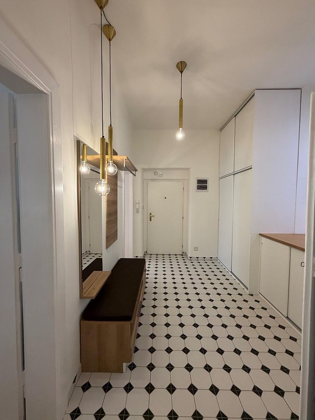 Předsíň s designovými svítidly a černobílou dlažbou