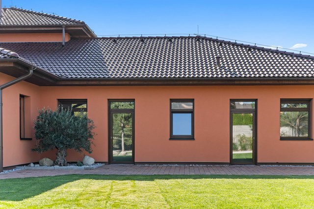 Zahradní průčelí domu s okny a dveřmi do zahrady