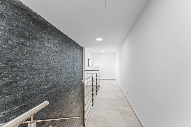 Galerie v patře podél kamenné stěny