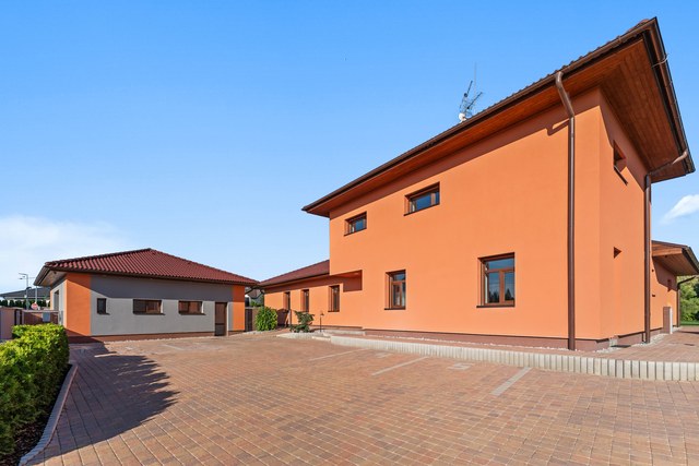 Dvoupodlažní dům s přízemními křídly u dvora